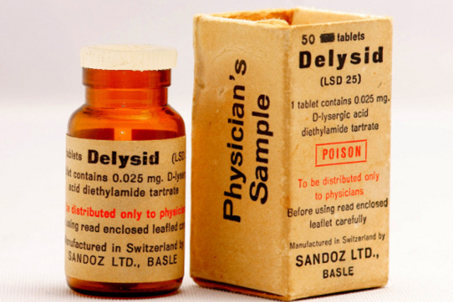 Image d'une boîte de Delysid, le nom commercial du LSD dans les années 1950-60, avec une étiquette rouge et blanche indiquant 'Delysid' et 'Sandoz'.